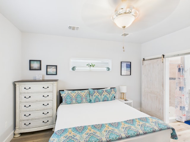 2403 S Bronte St, Rockport, TX 78382 - bedroom with wood finished floors, a barn door, and ceiling fan