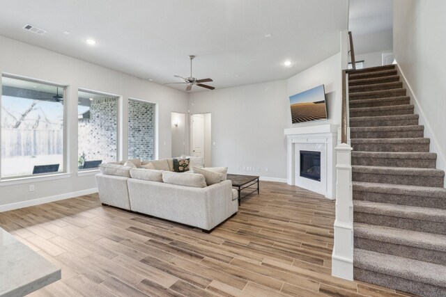 531 Campbell Dr, League City, TX 77573 - living area featuring ceiling fan, stairs, light wood-style floors, a glass covered fireplace, and recessed lighting