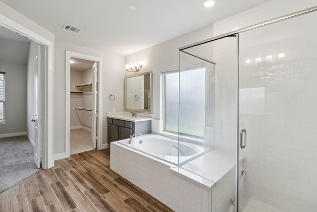 531 Campbell Dr, League City, TX 77573 - bathroom with a stall shower, a bath, vanity, a walk in closet, and wood finished floors