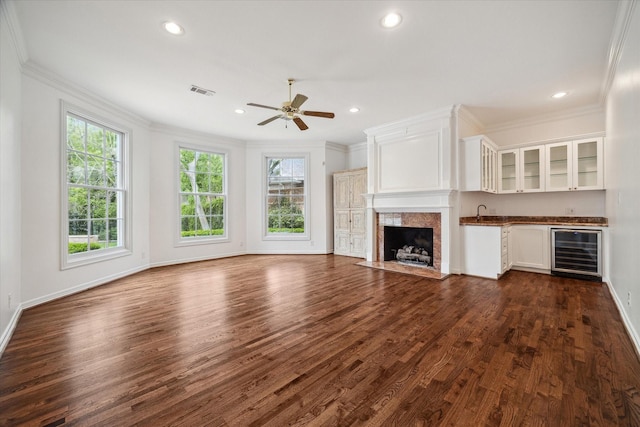 10918 Wickline Dr, Hunters Creek Village, TX 77024 - unfurnished living room featuring wine cooler, ornamental molding, plenty of natural light, dark wood-type flooring, and ceiling fan