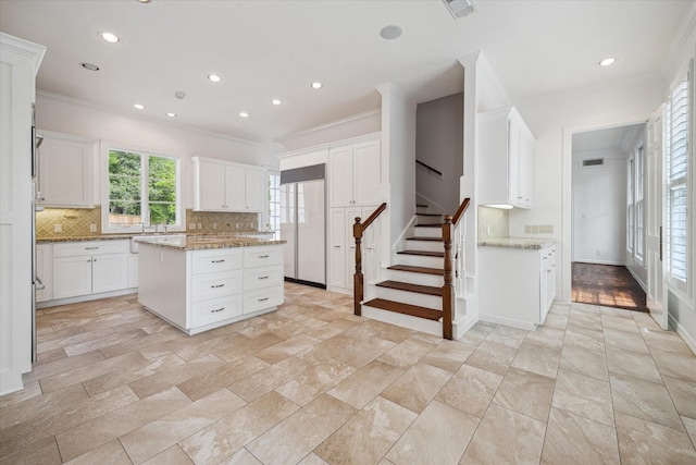 10918 Wickline Dr, Hunters Creek Village, TX 77024 - kitchen featuring backsplash, crown molding, recessed lighting, white cabinets, and light stone countertops