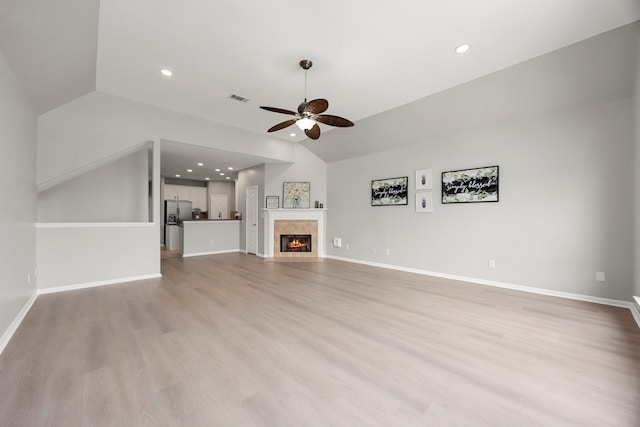 3639 Burning Palms Ct, Houston, TX 77042 - unfurnished living room with vaulted ceiling, a ceiling fan, light wood-style floors, a tiled fireplace, and baseboards