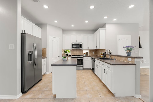 3639 Burning Palms Ct, Houston, TX 77042 - kitchen featuring stainless steel appliances, a sink, dark countertops, a peninsula, and a kitchen island