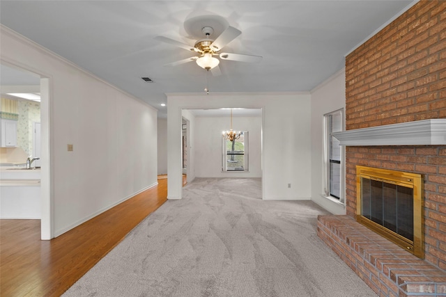 1925 E Lake Dr, Huntsville, TX 77340 - unfurnished living room with crown molding, a brick fireplace, a chandelier, a ceiling fan, and baseboards