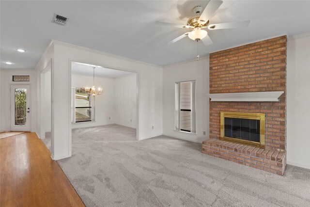 1925 E Lake Dr, Huntsville, TX 77340 - unfurnished living room with ornamental molding, a ceiling fan, a chandelier, a brick fireplace, and baseboards