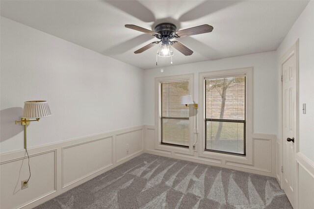 1925 E Lake Dr, Huntsville, TX 77340 - carpeted empty room featuring wainscoting, a ceiling fan, and a decorative wall