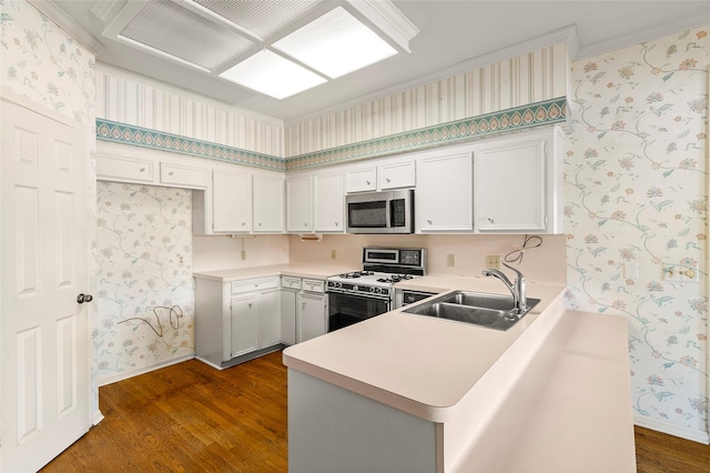 1925 E Lake Dr, Huntsville, TX 77340 - kitchen with stainless steel microwave, white range with gas cooktop, wallpapered walls, a sink, and dark wood-style flooring