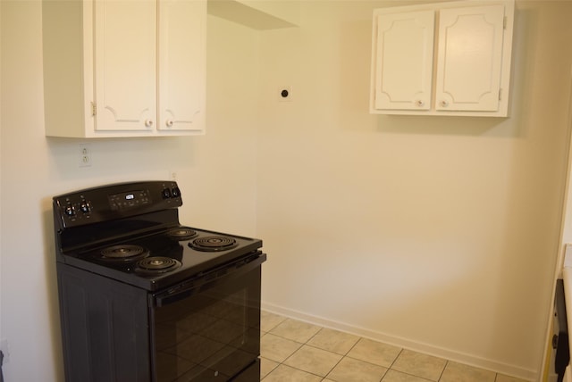 611 Glenvale Dr, Houston, TX 77060 - kitchen with black electric range oven, white cabinets, light tile patterned floors, and baseboards