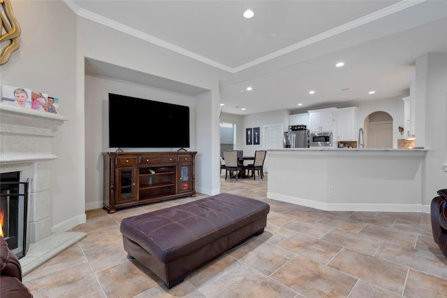 6003 Tarra Firma Dr, Spring, TX 77379 - living area with ornamental molding, arched walkways, a warm lit fireplace, and recessed lighting