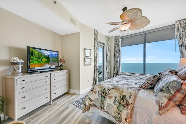 801 E Beach Dr Unit Bc2305, Galveston, TX 77550 - bedroom with access to exterior, light wood-style flooring, baseboards, ceiling fan, and a water view