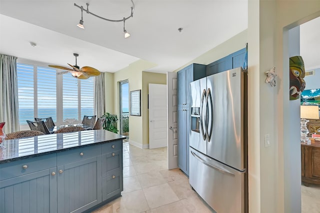 801 E Beach Dr Unit Bc2305, Galveston, TX 77550 - kitchen with stainless steel refrigerator with ice dispenser, dark stone countertops, a ceiling fan, light tile patterned flooring, and baseboards