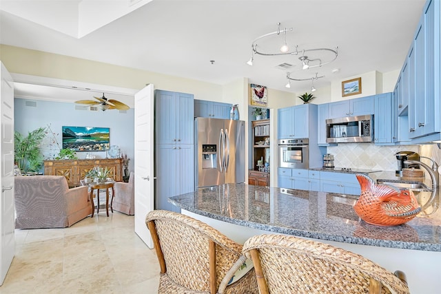 801 E Beach Dr Unit Bc2305, Galveston, TX 77550 - kitchen featuring stainless steel appliances, a sink, blue cabinets, a peninsula, and dark stone counters