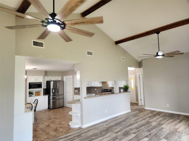 482 W Cattle Dr, Onalaska, TX 77360 - kitchen featuring stainless steel appliances, high vaulted ceiling, a ceiling fan, white cabinetry, and beam ceiling