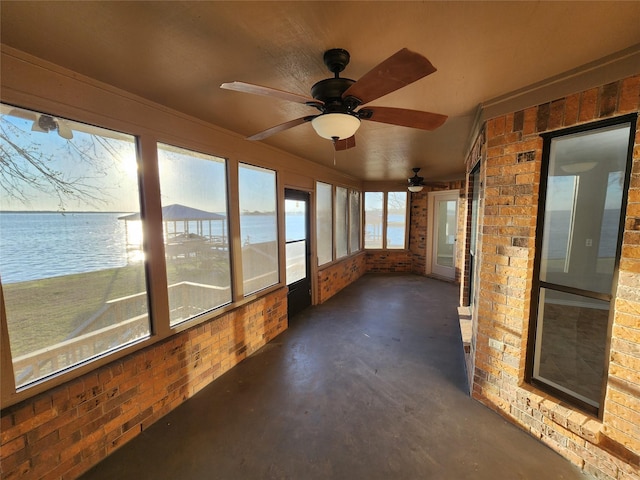 482 W Cattle Dr, Onalaska, TX 77360 - unfurnished sunroom with concrete floors, brick wall, ceiling fan, and a water view