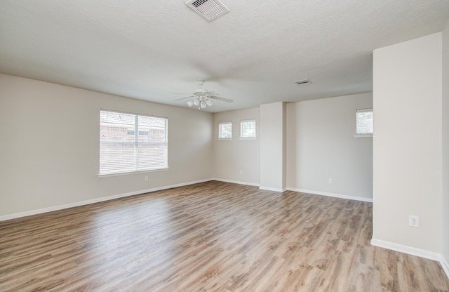 3410 Walden Creek Ln, Pearland, TX 77581 - empty room with light wood-style floors, ceiling fan, baseboards, and a textured ceiling