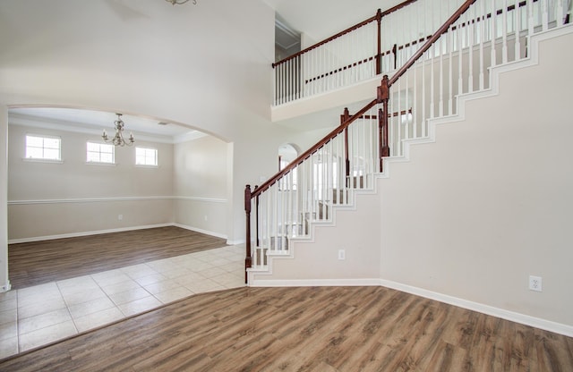 3410 Walden Creek Ln, Pearland, TX 77581 - foyer featuring arched walkways, a chandelier, wood finished floors, baseboards, and a towering ceiling