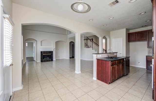 3410 Walden Creek Ln, Pearland, TX 77581 - kitchen with a sink, dishwashing machine, open floor plan, baseboards, and dark stone countertops