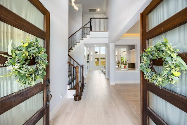 19111 N Frio River Cir, Cypress, TX 77433 - entryway featuring stairway, light wood-style floors, a high ceiling, and baseboards