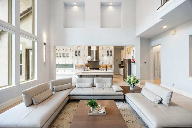 19111 N Frio River Cir, Cypress, TX 77433 - living room featuring a towering ceiling, baseboards, and light wood-type flooring