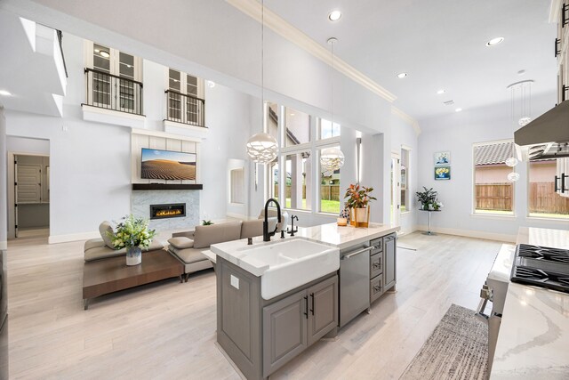19111 N Frio River Cir, Cypress, TX 77433 - kitchen featuring a sink, stainless steel dishwasher, open floor plan, a fireplace, and ornamental molding