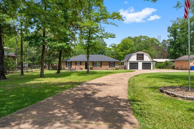 31614 Debbi Ln, Magnolia, TX 77355 - view of front facade featuring a detached garage, an outbuilding, concrete driveway, and view of wooded area