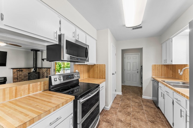 31614 Debbi Ln, Magnolia, TX 77355 - kitchen with appliances with stainless steel finishes, a sink, tasteful backsplash, light countertops, and white cabinets