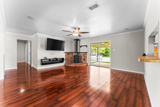 31614 Debbi Ln, Magnolia, TX 77355 - unfurnished living room with a wood stove, ceiling fan, baseboards, wood finished floors, and ornamental molding