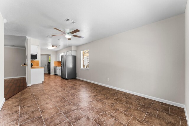 31614 Debbi Ln, Magnolia, TX 77355 - unfurnished living room with baseboards, a ceiling fan, and dark tile patterned flooring