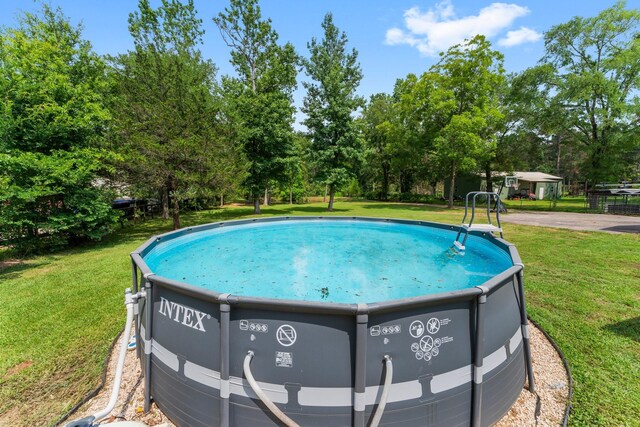 31614 Debbi Ln, Magnolia, TX 77355 - view of swimming pool featuring view of wooded area and a yard