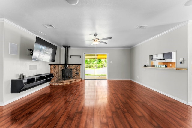 31614 Debbi Ln, Magnolia, TX 77355 - unfurnished living room with wood finished floors, a ceiling fan, a wood stove, baseboards, and crown molding