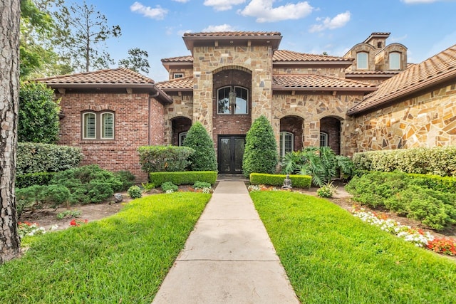 27919 Hansons Ct, Spring, TX 77386 - view of front of home featuring a tiled roof, stone siding, a front yard, and brick siding