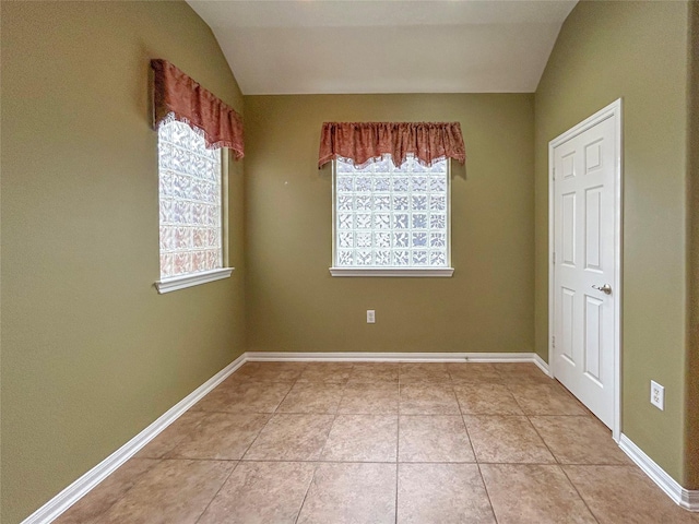 1314 Varese Dr, Pearland, TX 77581 - spare room featuring plenty of natural light, vaulted ceiling, light tile patterned floors, and baseboards
