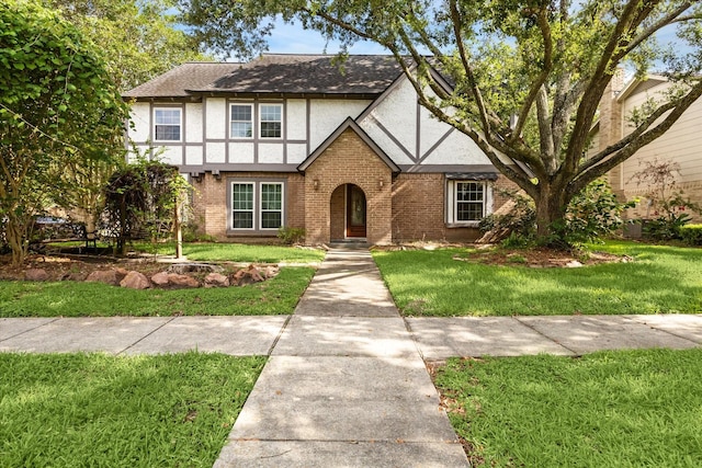 16201 Singapore Ln, Jersey Village, TX 77040 - tudor home featuring stucco siding, brick siding, and a front yard