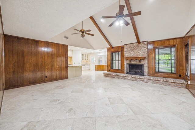 16201 Singapore Ln, Jersey Village, TX 77040 - unfurnished living room with high vaulted ceiling, wooden walls, a ceiling fan, a fireplace, and beam ceiling