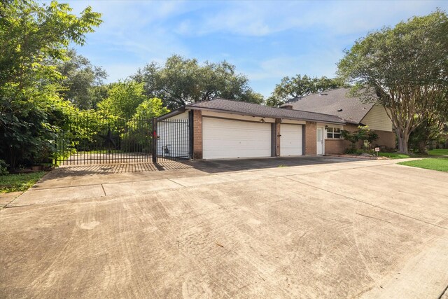 16201 Singapore Ln, Jersey Village, TX 77040 - garage featuring concrete driveway and a gate