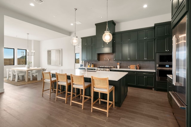 6727 Pine Haven Ct, Katy, TX 77493 - kitchen featuring stainless steel appliances, light countertops, backsplash, dark wood-type flooring, and recessed lighting