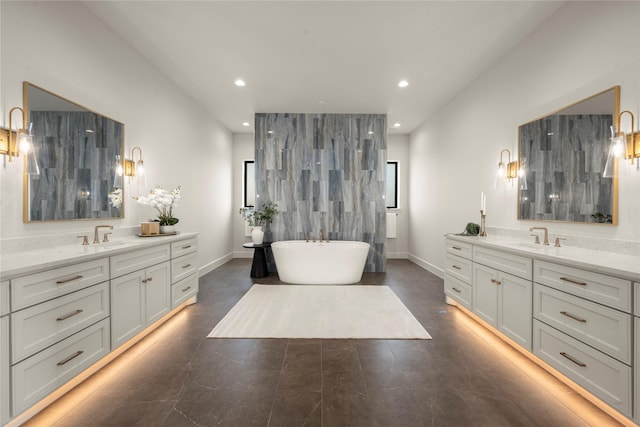 6727 Pine Haven Ct, Katy, TX 77493 - bathroom featuring two vanities, a freestanding tub, recessed lighting, and baseboards