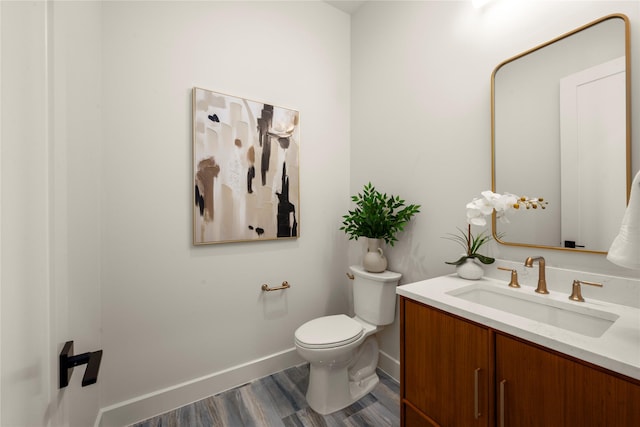 6727 Pine Haven Ct, Katy, TX 77493 - bathroom with vanity, toilet, baseboards, and wood finished floors