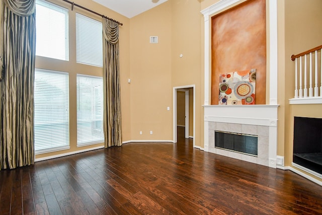 1623 Heddon Falls Dr, Sugar Land, TX 77479 - unfurnished living room featuring a towering ceiling, a fireplace, wood-type flooring, and baseboards