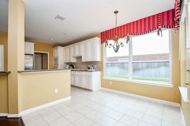 1623 Heddon Falls Dr, Sugar Land, TX 77479 - kitchen featuring high end refrigerator, white cabinetry, dark stone counters, and baseboards