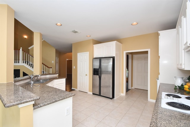 1623 Heddon Falls Dr, Sugar Land, TX 77479 - kitchen with stainless steel fridge, a sink, white electric stovetop, white cabinetry, and dark stone countertops