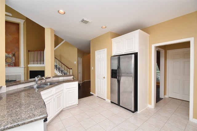 1623 Heddon Falls Dr, Sugar Land, TX 77479 - kitchen with stainless steel refrigerator with ice dispenser, a sink, white cabinets, recessed lighting, and a fireplace