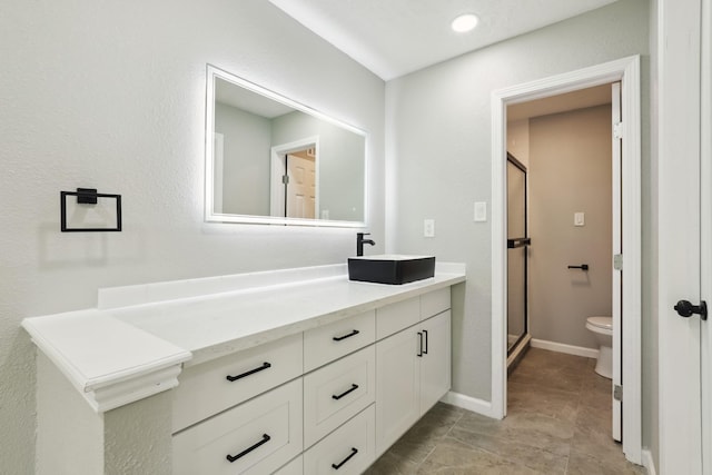 10007 Sagedowne Ln, Houston, TX 77089 - bathroom featuring toilet, vanity, a stall shower, and baseboards
