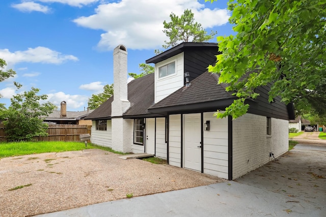 10007 Sagedowne Ln, Houston, TX 77089 - back of property featuring brick siding, a shingled roof, and a chimney