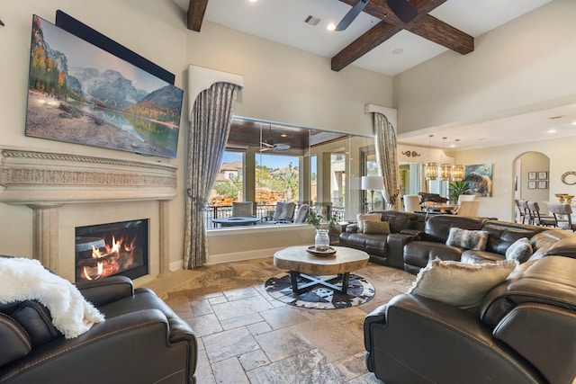 13 Pleasant Shadows Dr, Spring, TX 77389 - living room with ceiling fan, stone tile floors, beam ceiling, a glass covered fireplace, and a towering ceiling