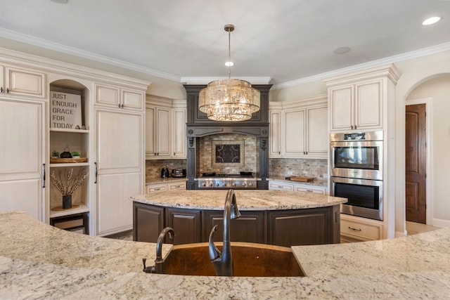 13 Pleasant Shadows Dr, Spring, TX 77389 - kitchen featuring cream cabinets, appliances with stainless steel finishes, a sink, light stone counters, and crown molding