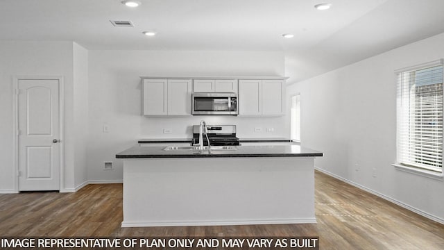 1354 Heather Rosewood Ln, Conroe, TX 77301 - kitchen featuring stainless steel appliances, a sink, dark countertops, wood finished floors, and recessed lighting