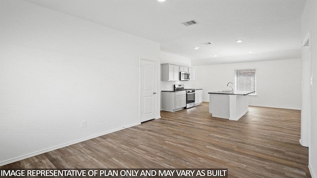 1354 Heather Rosewood Ln, Conroe, TX 77301 - kitchen featuring stainless steel appliances, a sink, dark wood finished floors, a kitchen island with sink, and recessed lighting