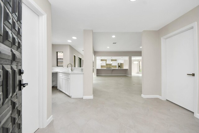 15707 Steamboat Ln, Houston, TX 77079 - hallway featuring light colored carpet, baseboards, recessed lighting, and a sink