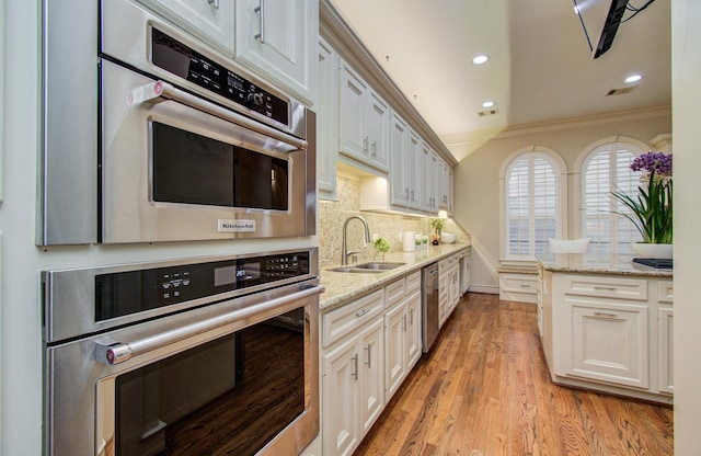 4310 Feagan St Unit A, Houston, TX 77007 - kitchen with stainless steel appliances, ornamental molding, decorative backsplash, a sink, and recessed lighting